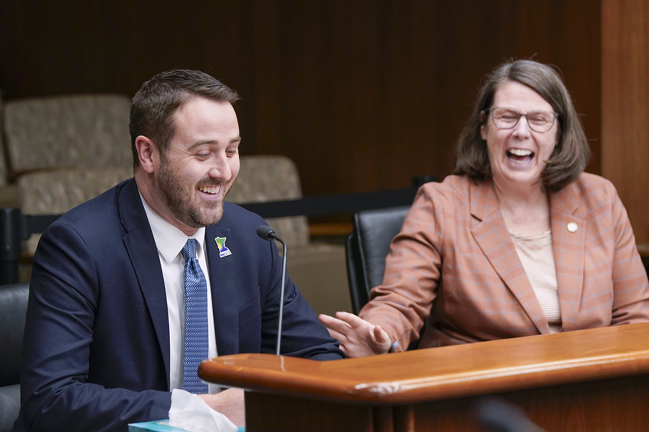 Logan O'Grady, executive director of the Minnesota Solar Energy Industries Association, shares a laugh with Rep. Patty Acomb April 3 before testifying before the House Climate and Energy Finance and Policy Committee. Acomb sponsors HF5097. (Photo by Michele Jokinen) 
